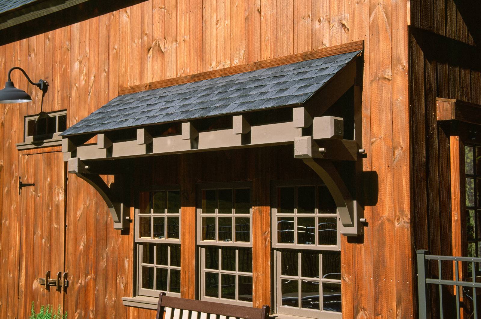 Close up: timber frame eyebrow roof over 3 barn windows