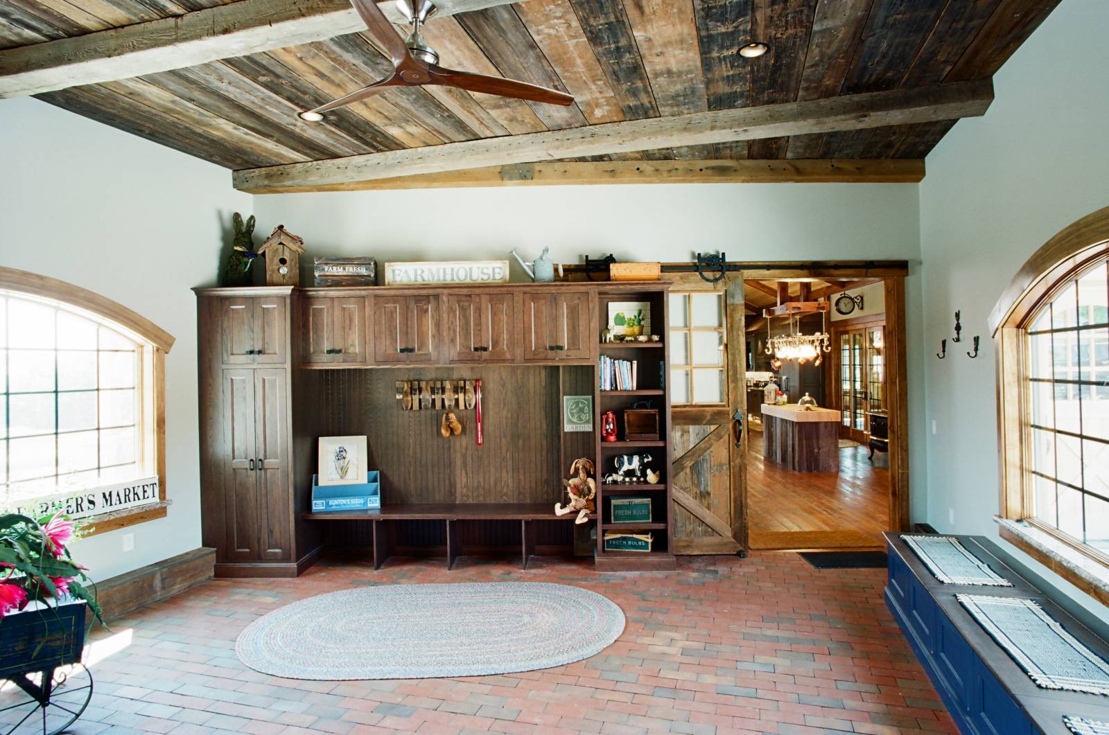 In the Entry: Reclaimed Barn Wood Ceiling • Arched Bow Top Windows • Sliding Barn Door • Brick Floor