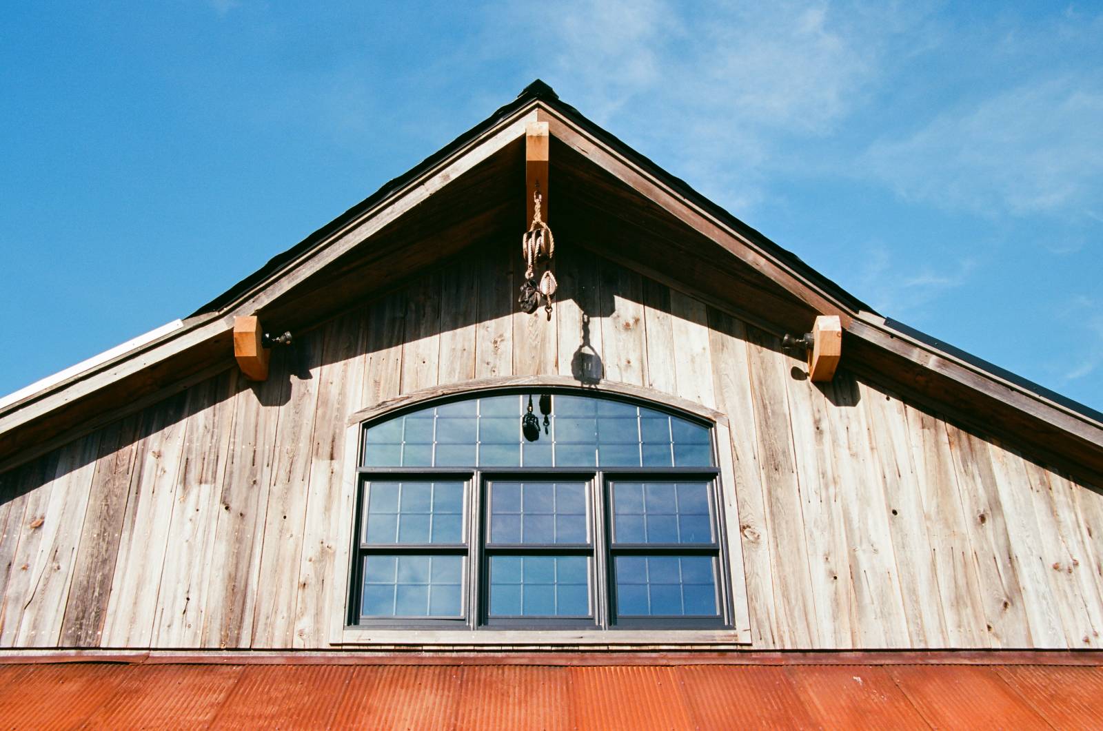 Arched Bow Top Window • Reclaimed Barn Board Siding • Timber Accents •Â Cow Catcher Peak