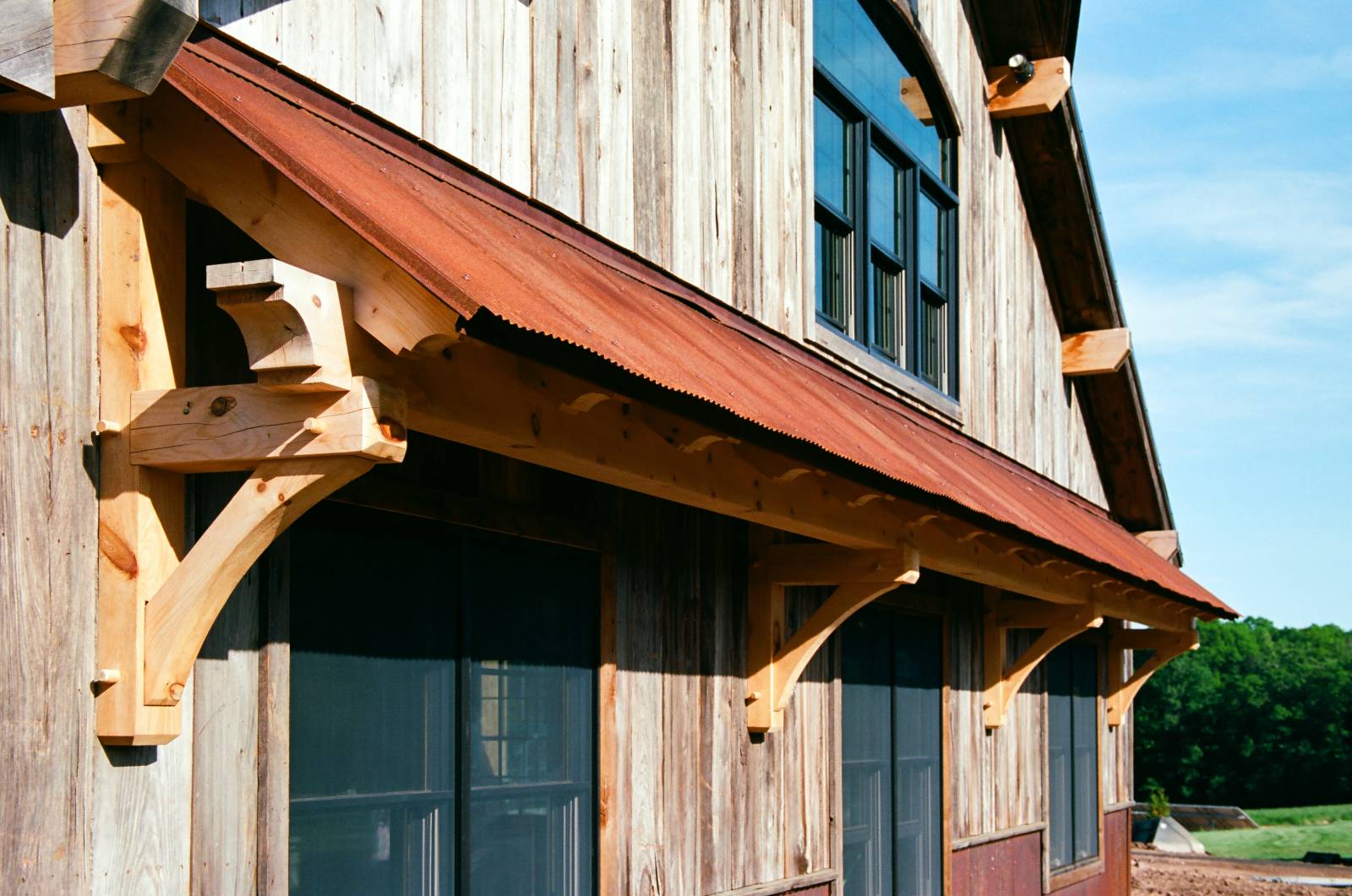 Timber Frame Eyebrow Roof with Rusty Metal Roof