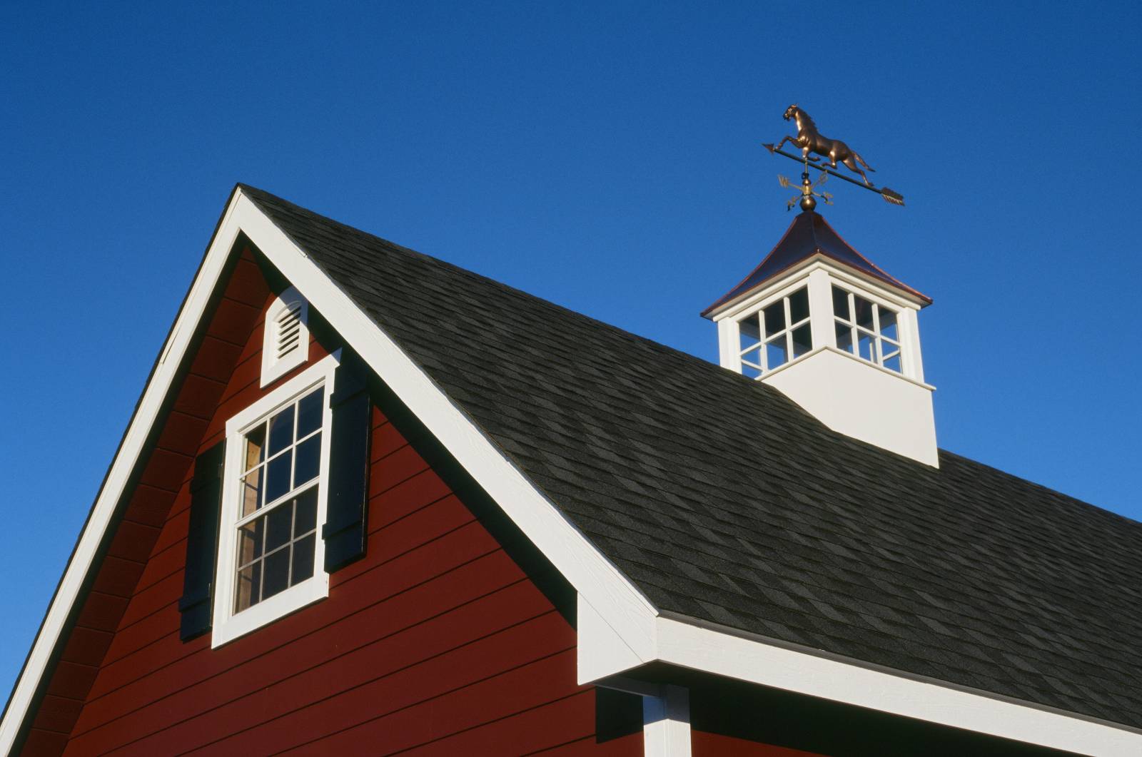 Bold inspiring colors: barn red siding • black shutters • white trim • blue sky • copper top cupola & weathervane