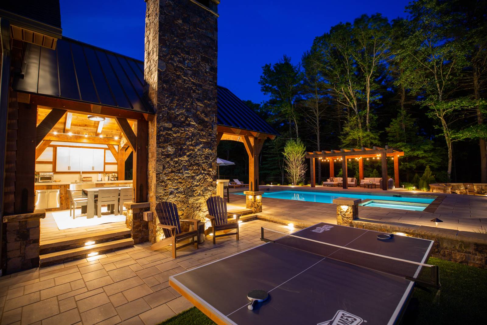 Table Games Next To the Pavilion • Farther Back, The Pool and a Timber Frame Pergola