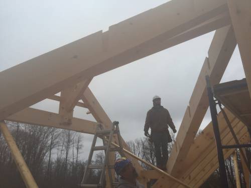 Timber frame crew building the dormer in the fog