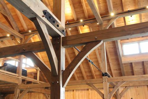 Timber frame with tension rod between posts