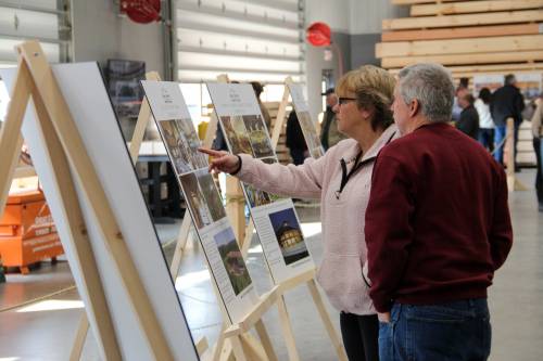 A couple reads a poster about a recently built party barn