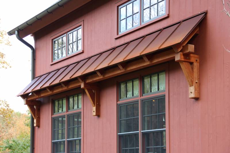 Timber Frame Eyebrow Roof with Standing Seam Rusty Metal Roof