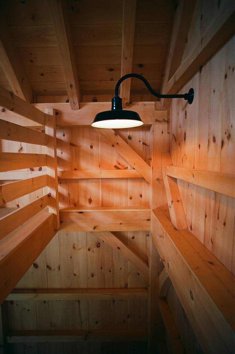 Authentic timber frame joinery in stairwell with gooseneck light