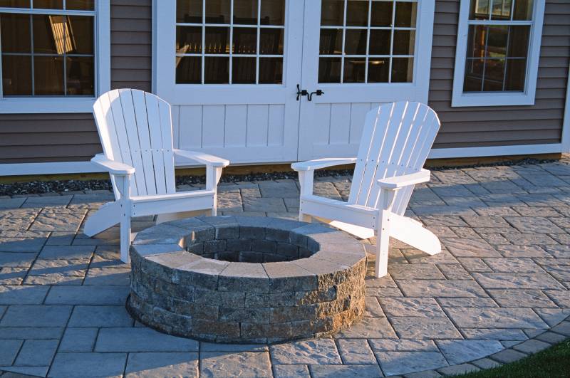 White poly Adirondack chairs by fire pit