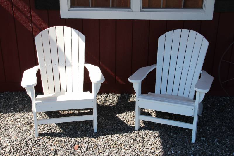 Two white poly Adirondack chairs