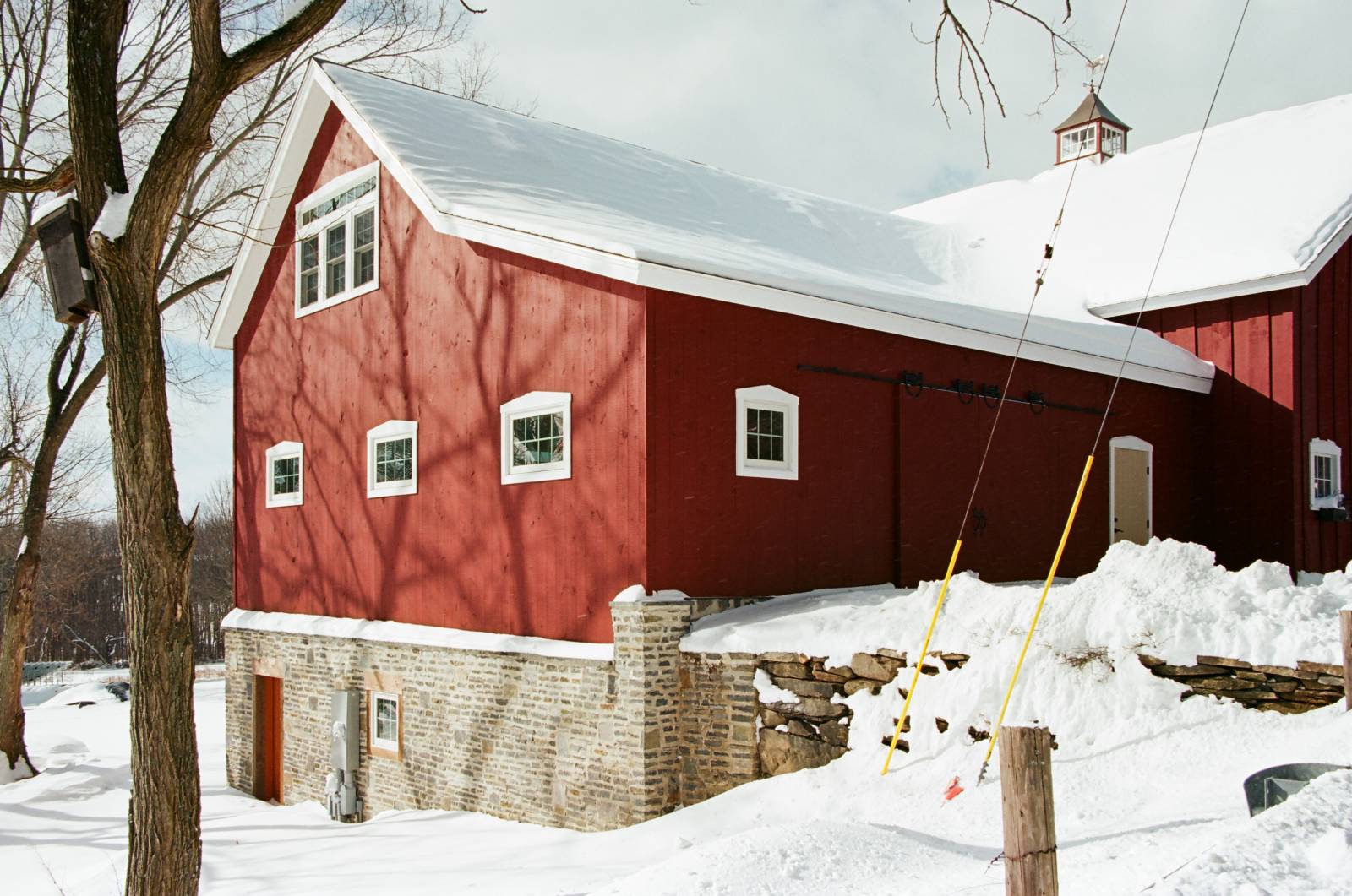 Post & beam barn built into a hill with stone veneer on foundation