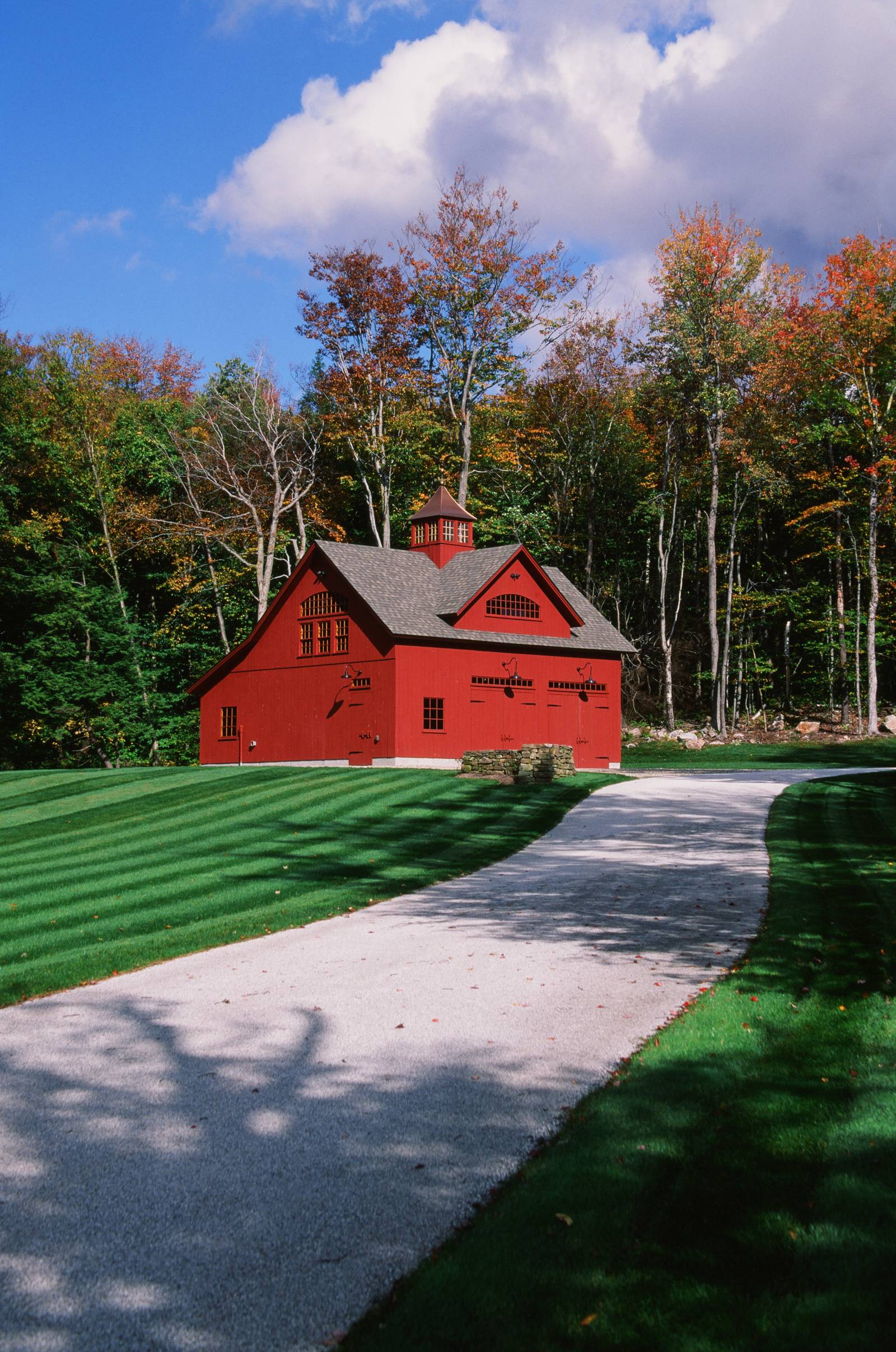 A red Carriage Barn surrounded by the gorgeous fall colors of autumn in Vermont