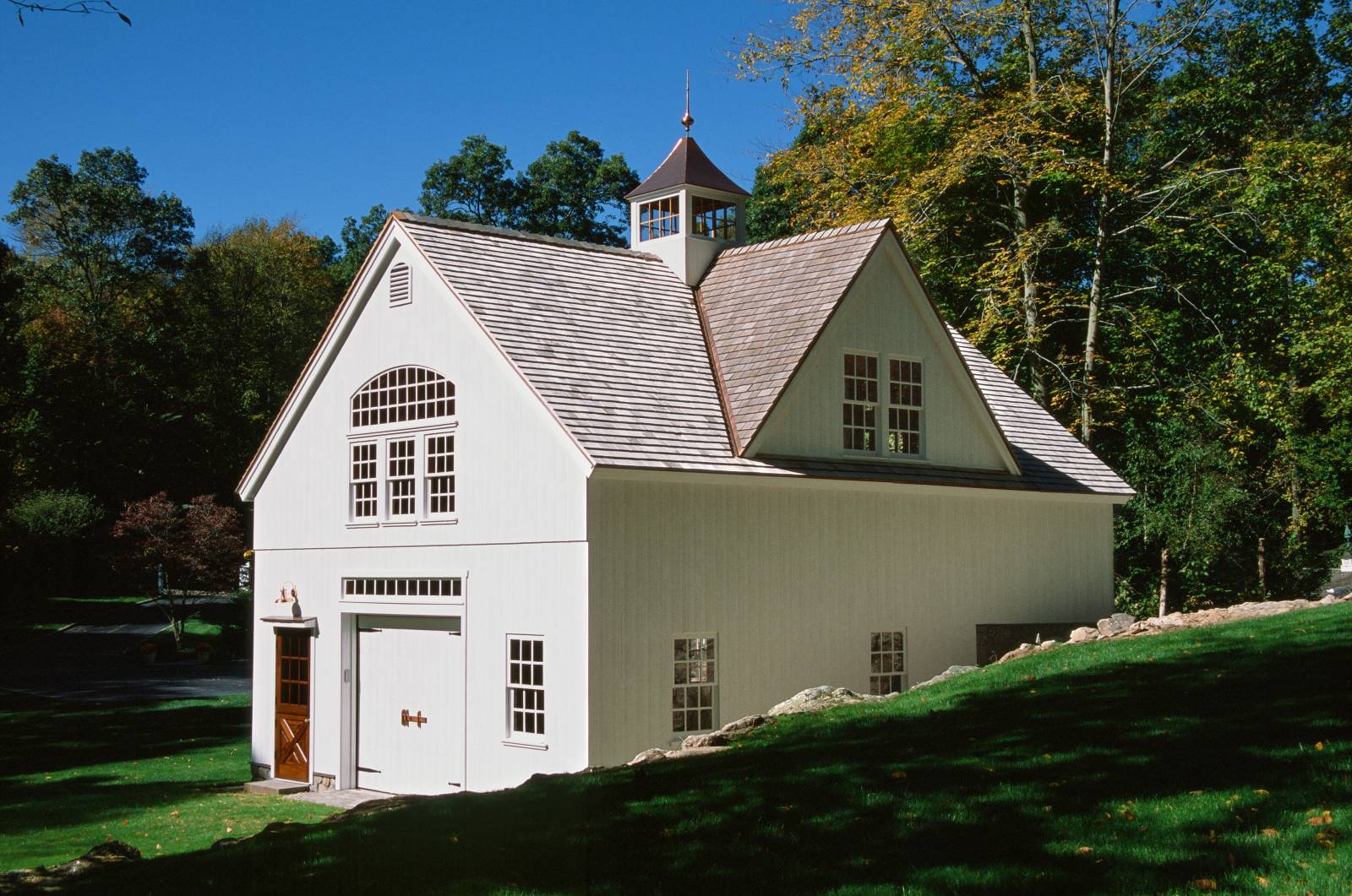 The bank barn features a reverse gable dormer facing the hillside