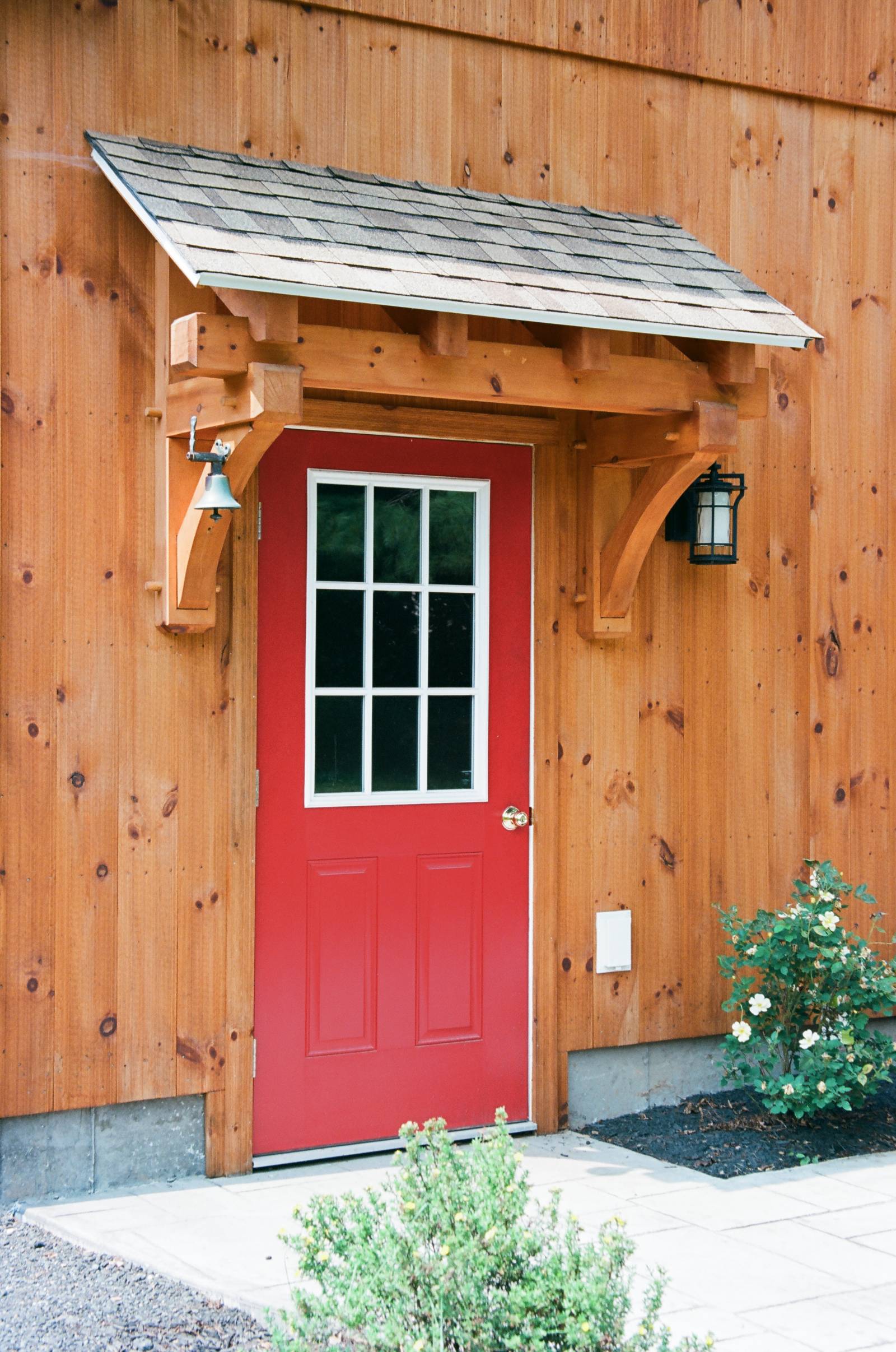 Entry door with timber frame eyebrow roof