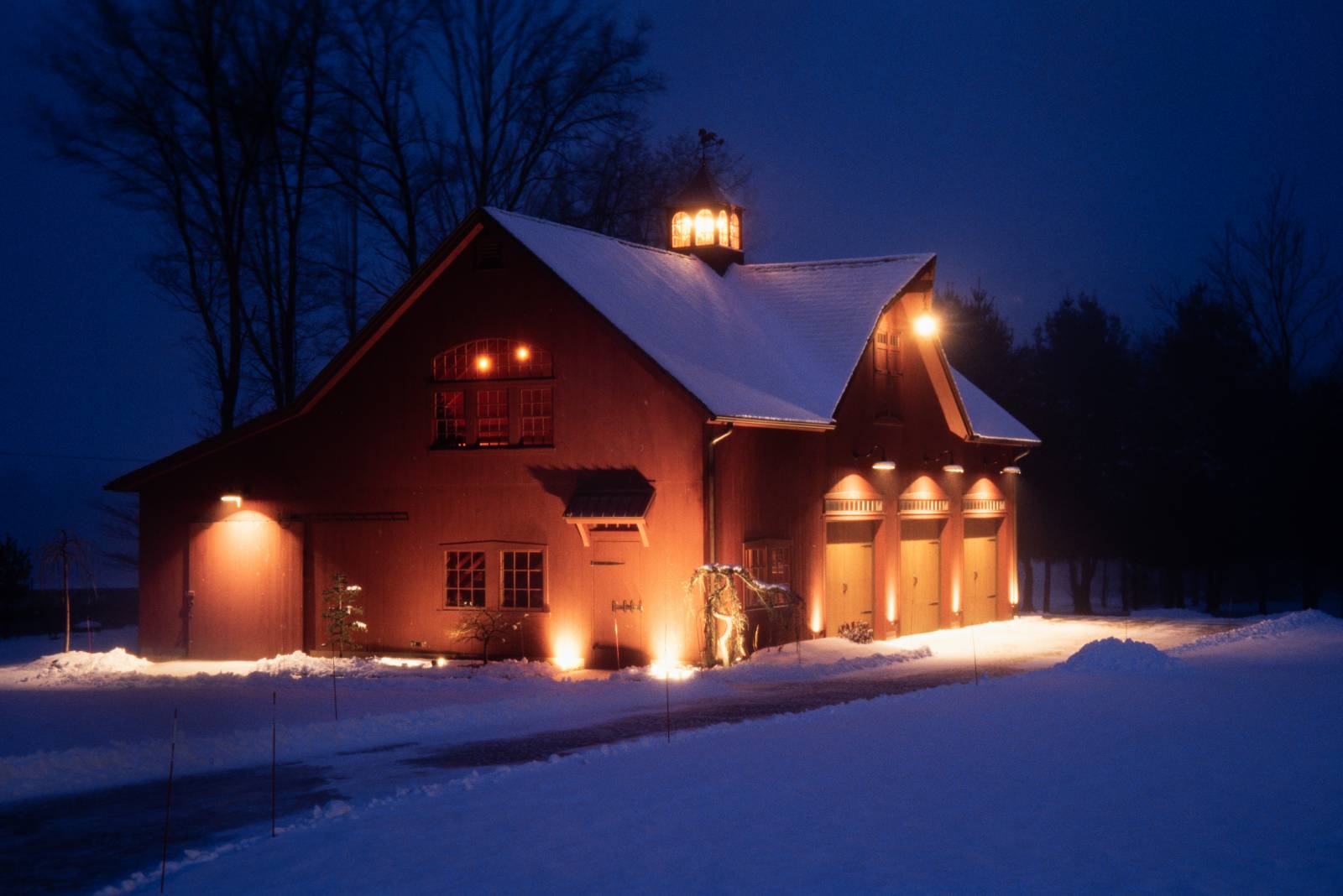 The Carriage Barn is a shining beacon of light during the snow squall as dusk turns to night