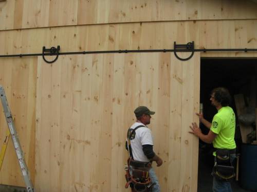 Working on the pine sliding barn door with horseshoe track hardware
