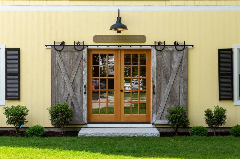 Side entrance with sliding barn doors on horseshoe track & full view glass double doors