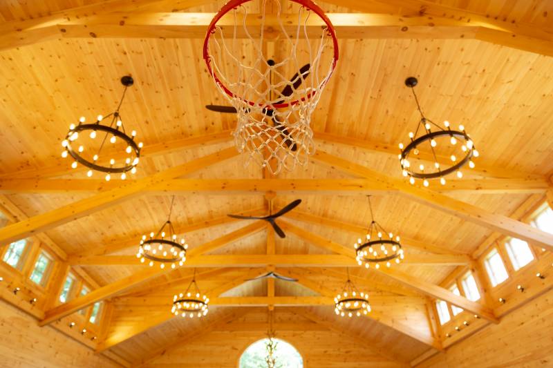Under the basketball hoop with the timber trusses in the background