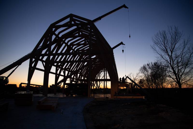 Crew and barn frame silhouetted against the sunset