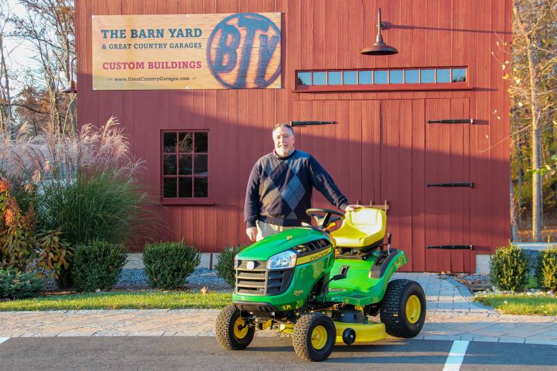 Bill R. and his prize tractor in front of a post & beam barn at The Barn Yard's Bethel CT location