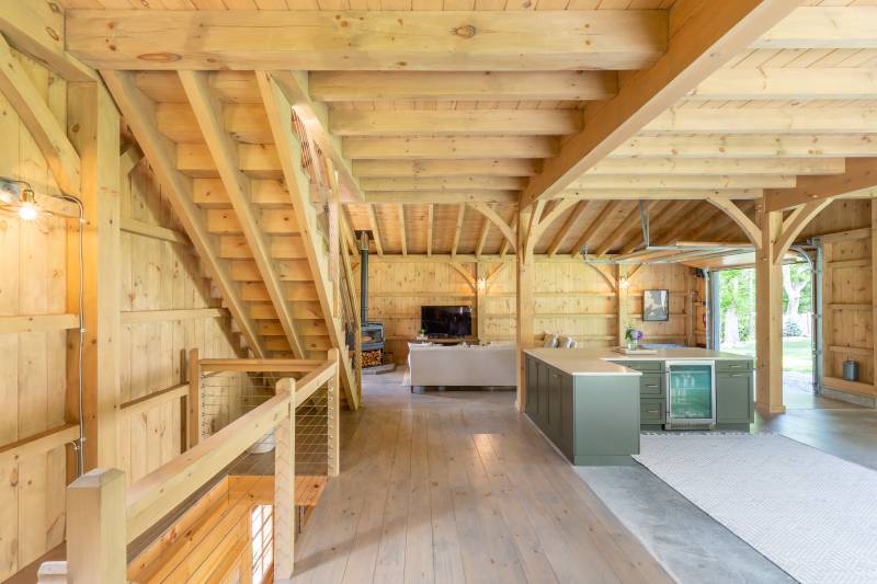 On the main floor of the Lenox Carriage Barn • Clear span Douglas Fir beams • Stairs going up to loft & down to walk-out basement